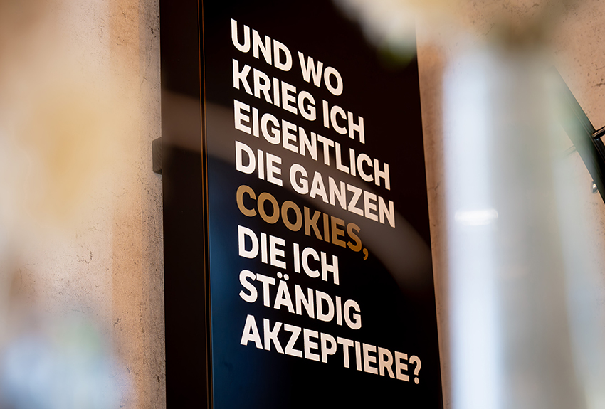 Modernes Schild in einer Bäckerei mit der Aufschrift Und wo kireg ich eigentlich die ganzen Cookies, die ich ständig akzeptiere?