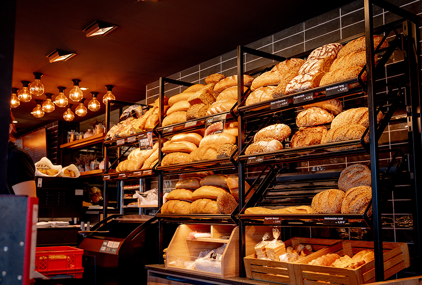 Volle Theke einer modern eingerichteten Bäckerei mit frischem Brot